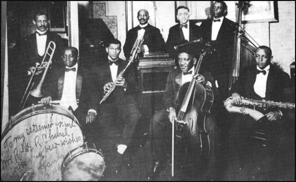 W.C. Handy is pictured with his Memphis Orchestra ca. 1918, in center rear, wearing a moustache, holding his trumpet.